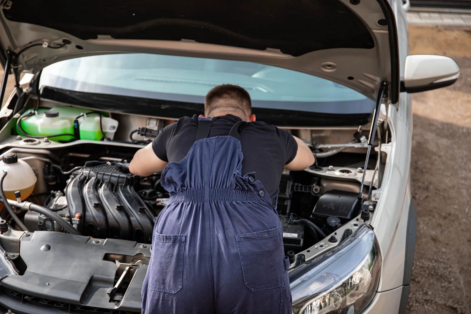 Mechanic leaning into an open engine bay